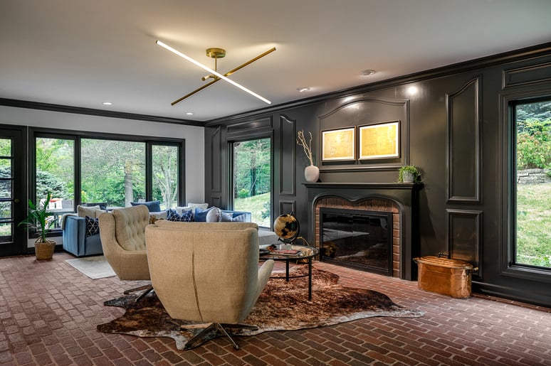 Renovated Living Room in Des Moines, Iowa with dark walls fire place and brick flooring