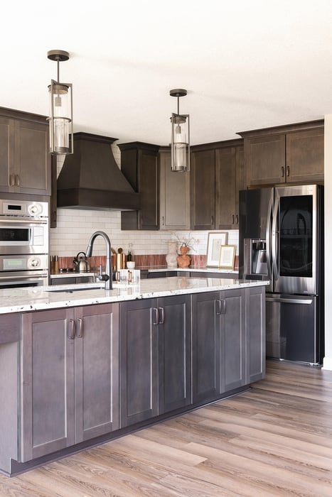 Custom dark kitchen cabinets on a large kitchen island with white countertops