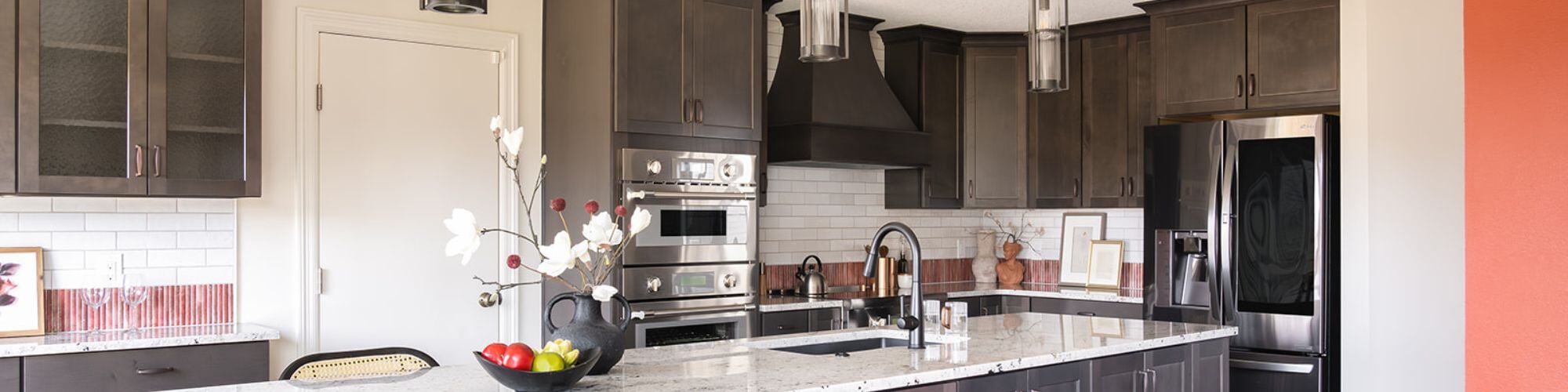 Kitchen remodel in Urbandale, IA with dark cabinets, custom lighting, and large kitchen island with white countertop 