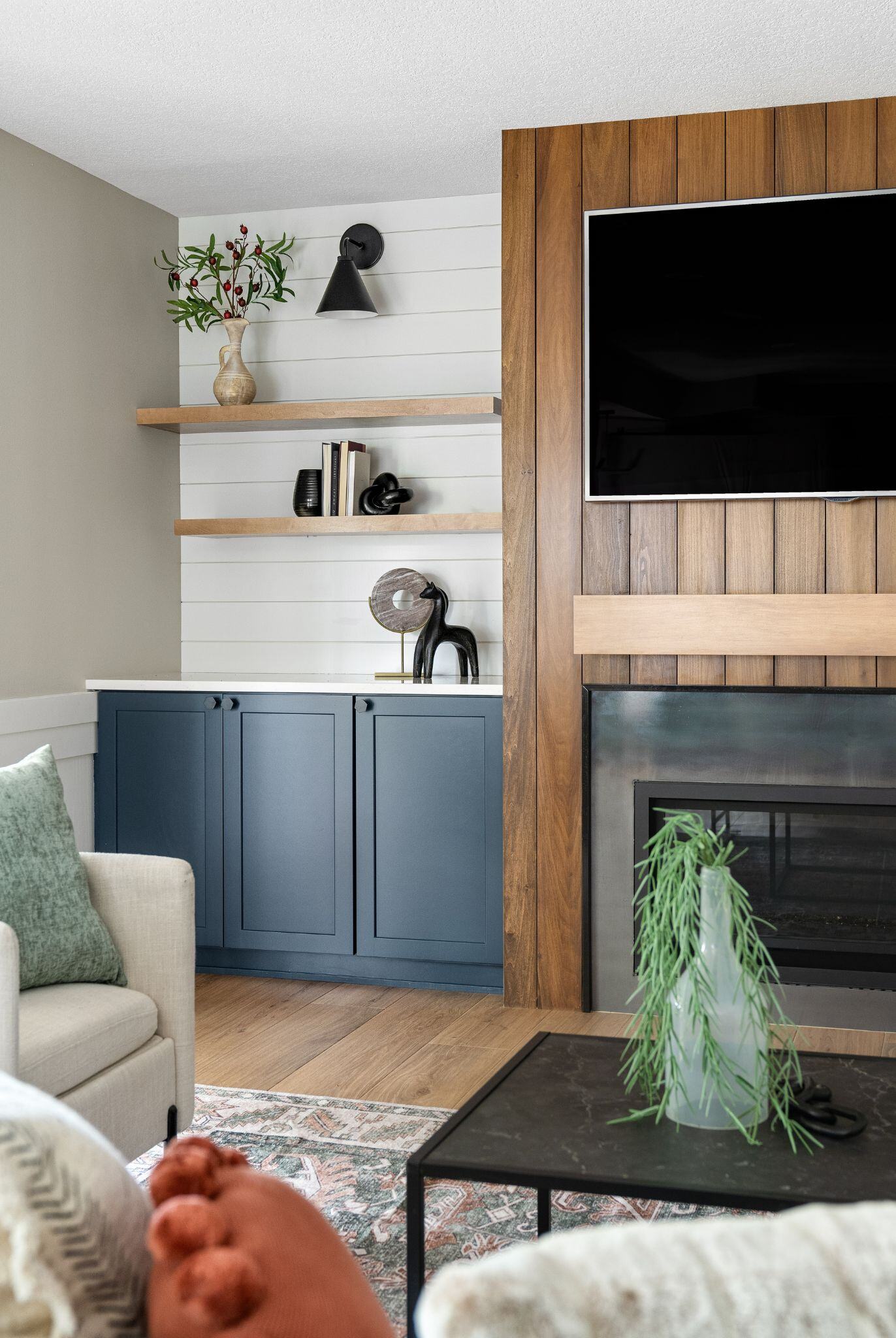 modern fireplace remodel with wooden panels and cabinets and shelving on the side