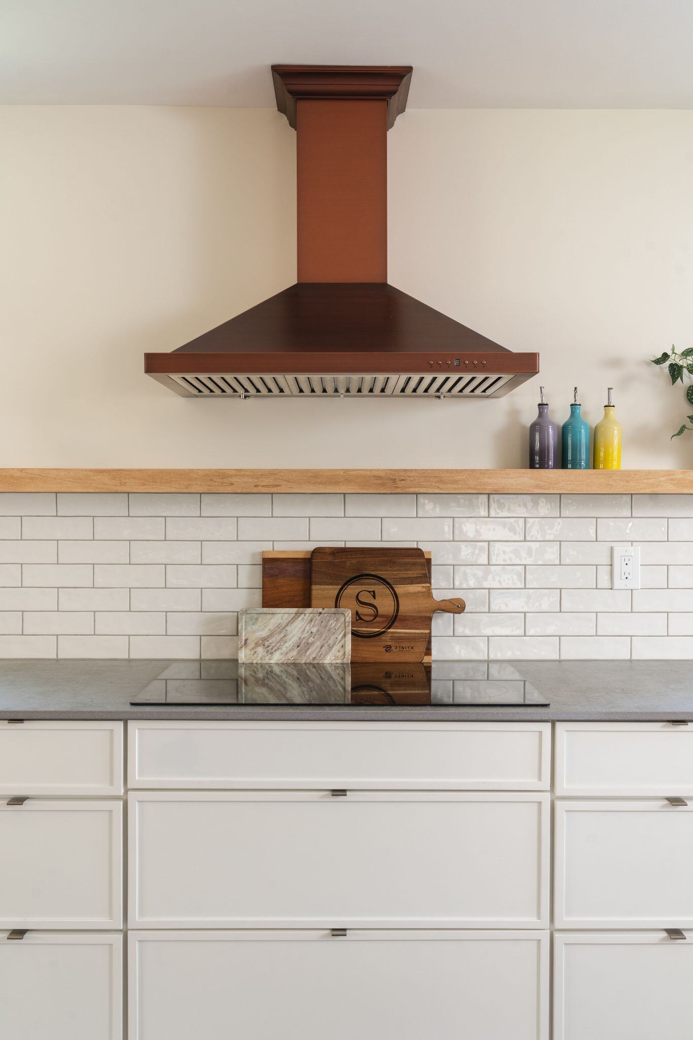 Copper vent hood in a modern white kitchen