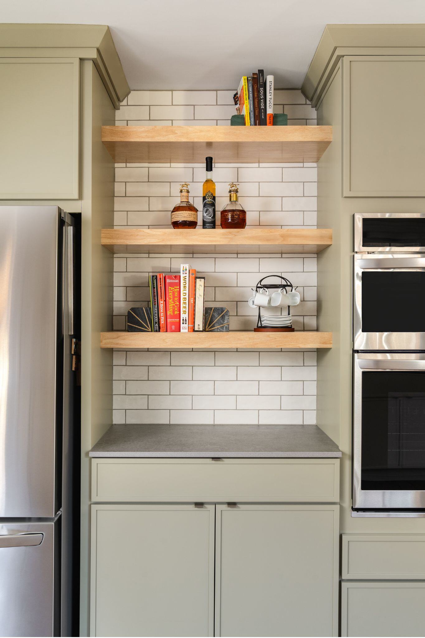 sage green kitchen cabinets with stainless steel appliances and open shelving