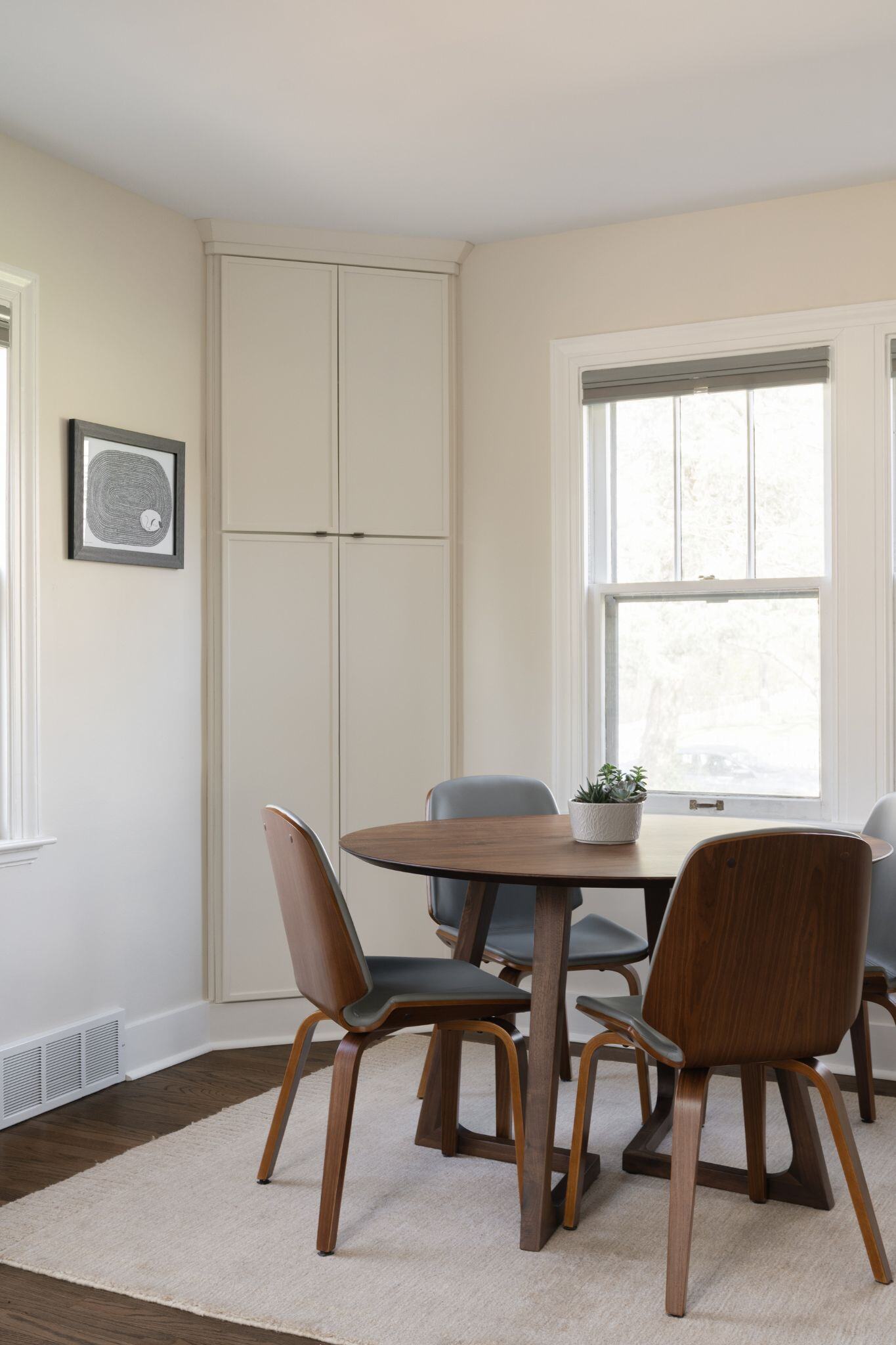 Dark wooden dining room table in a modern white dining room remodel