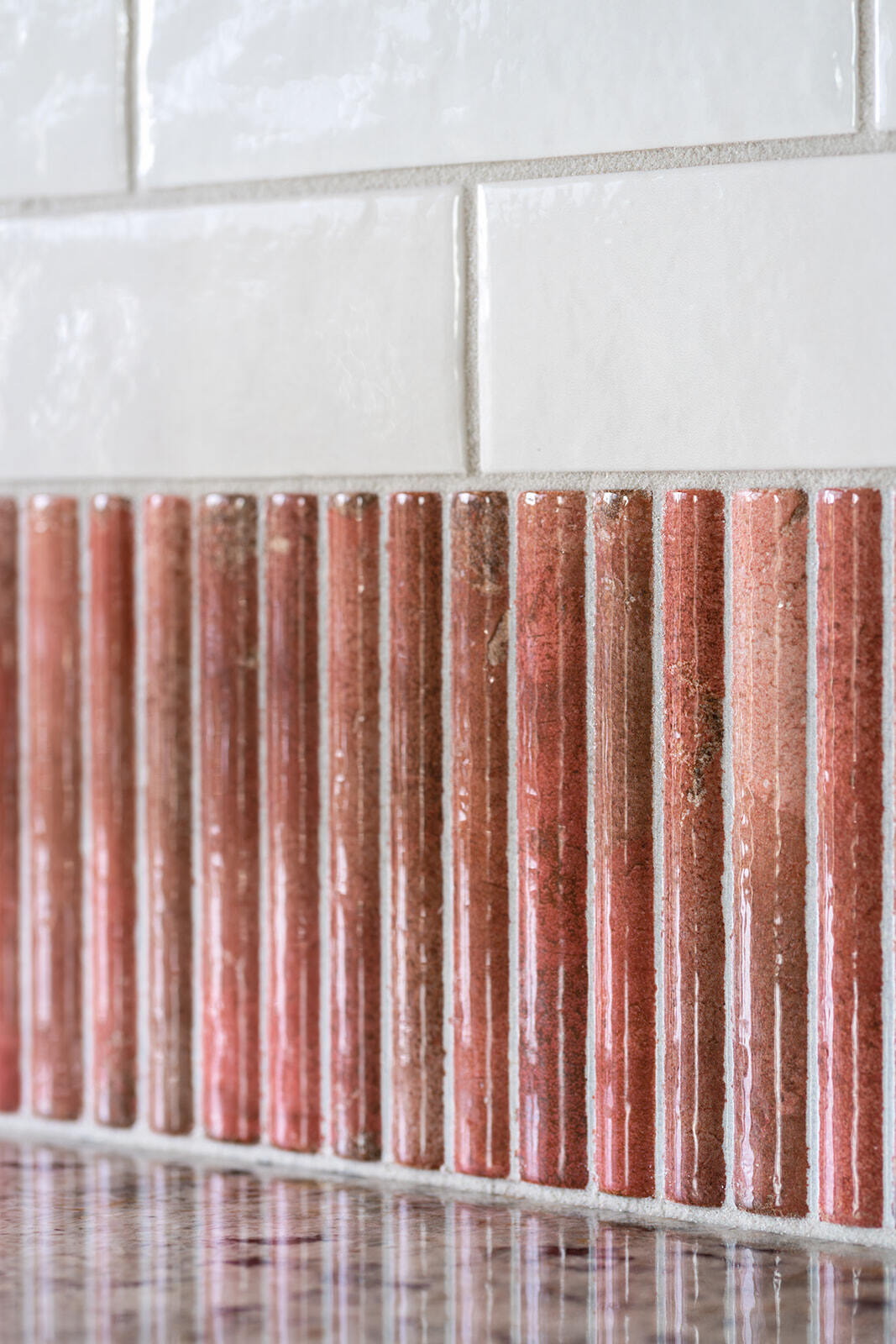 Detail shot of Coral stone narrow, vertical kitchen backsplash tile white subway tile as kitchen backsplash