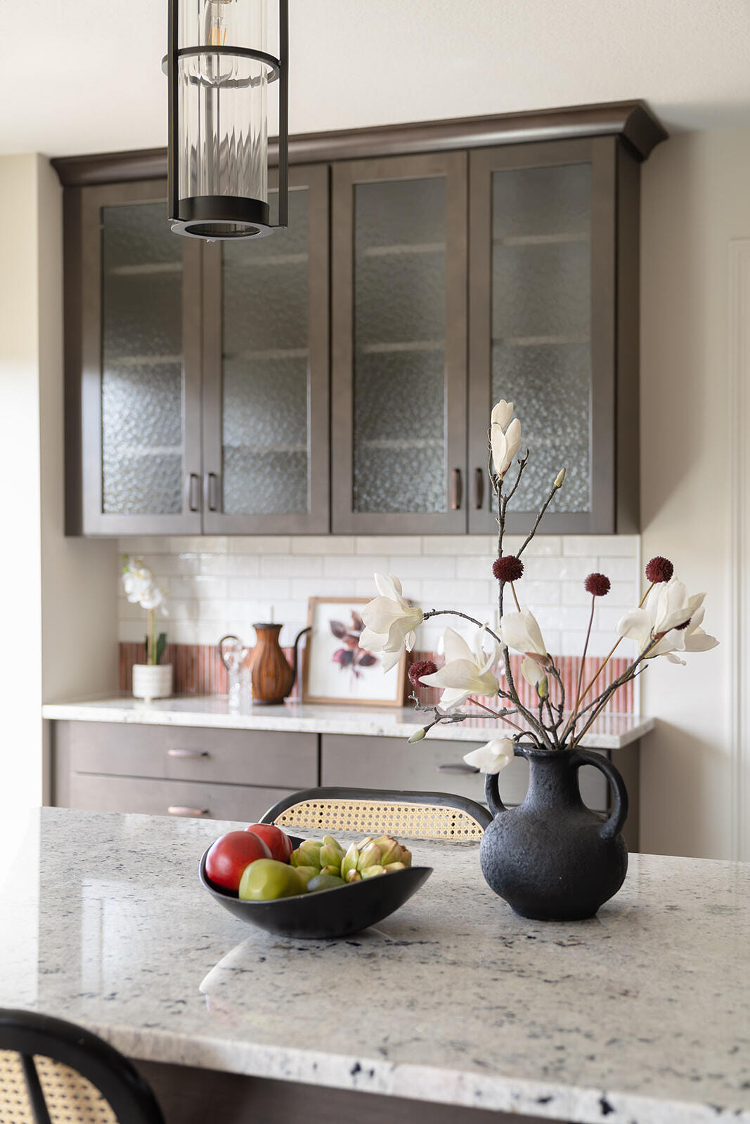 White and black speckled kitchen island countertop with fruit basket in a remodeled kitchen in des moines, Iowa area.