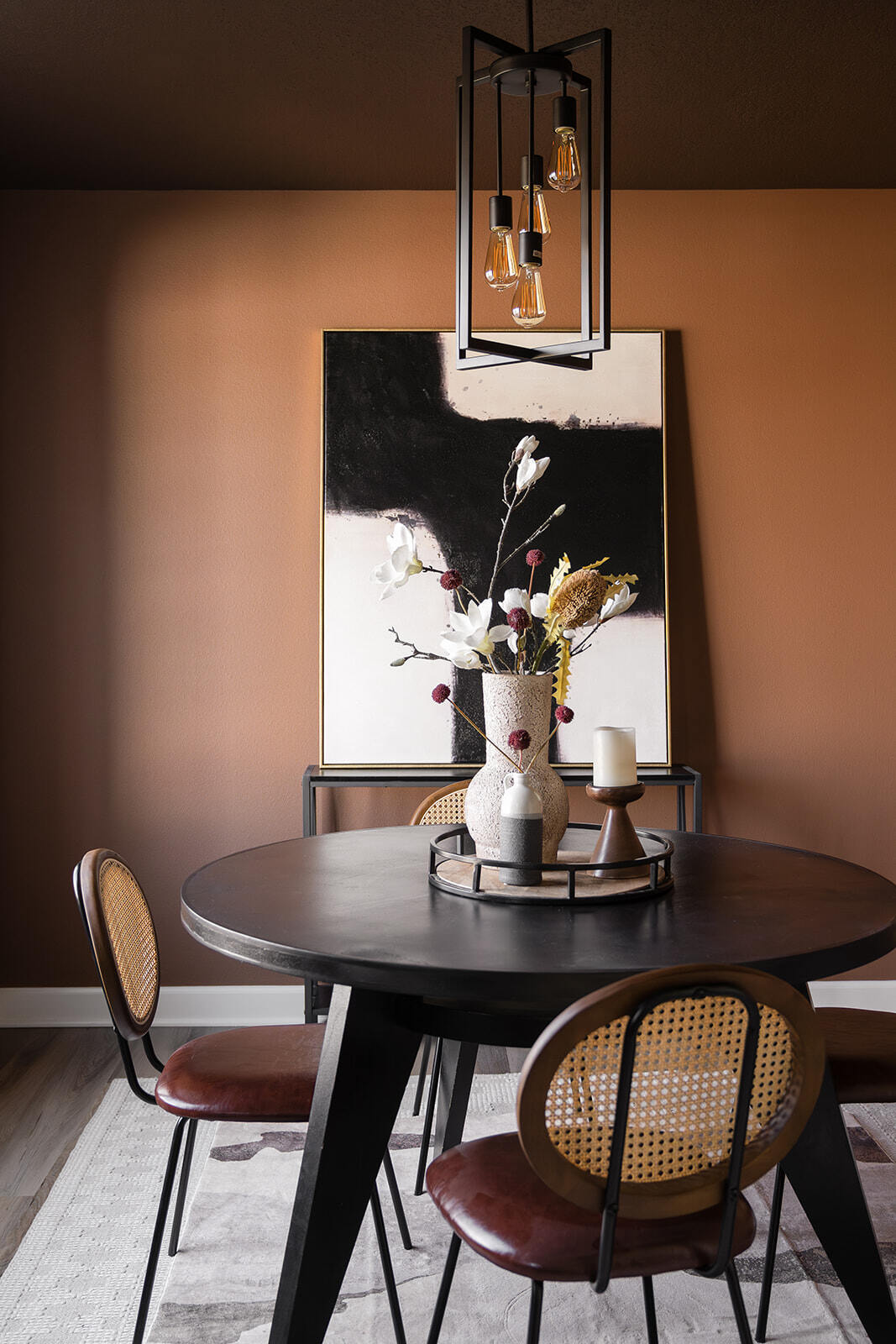 Dark remodeled dining room with custom lighting and wooden floors in des moines Iowa area