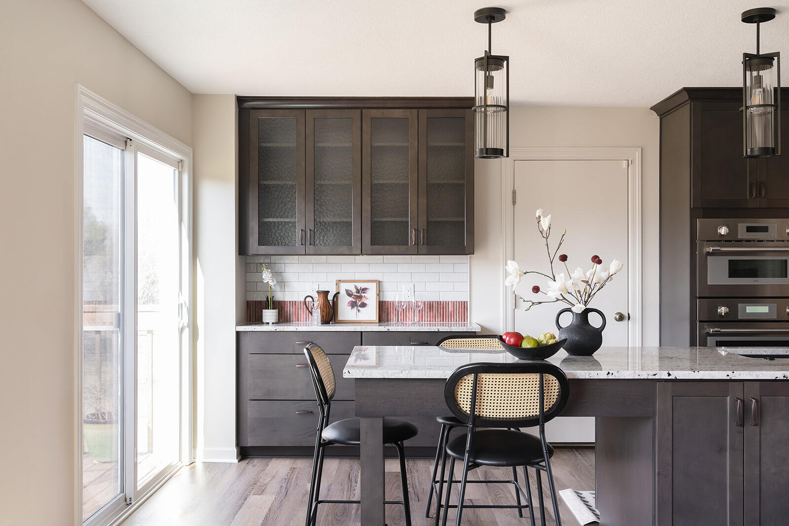 Kitchen renovation in Urbandale, IA with dark cabinets and custom lighting and backsplash