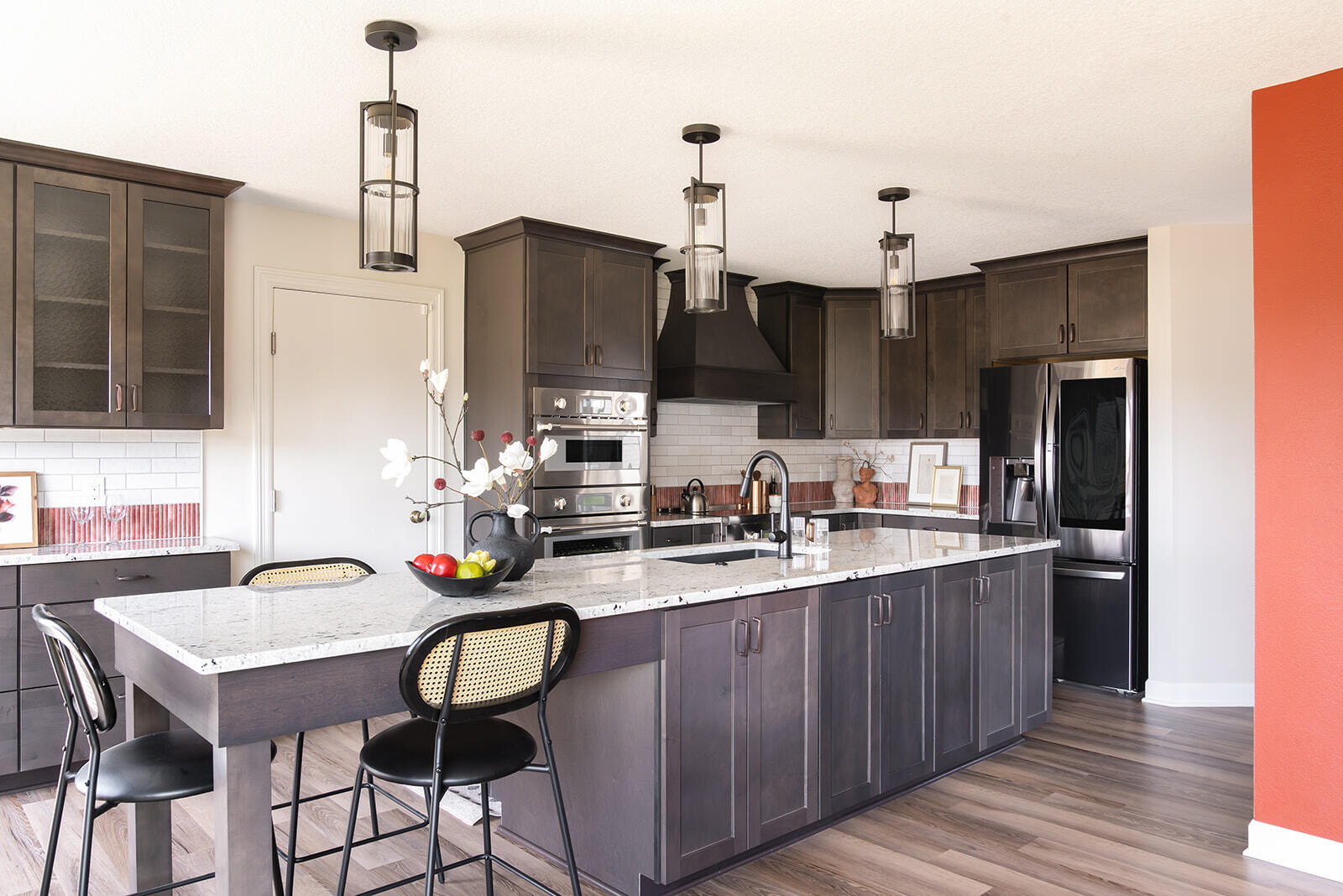 Wide view of kitchen renovation in Urbandale IA with large kitchen island with bar stools and abundant cabinetry