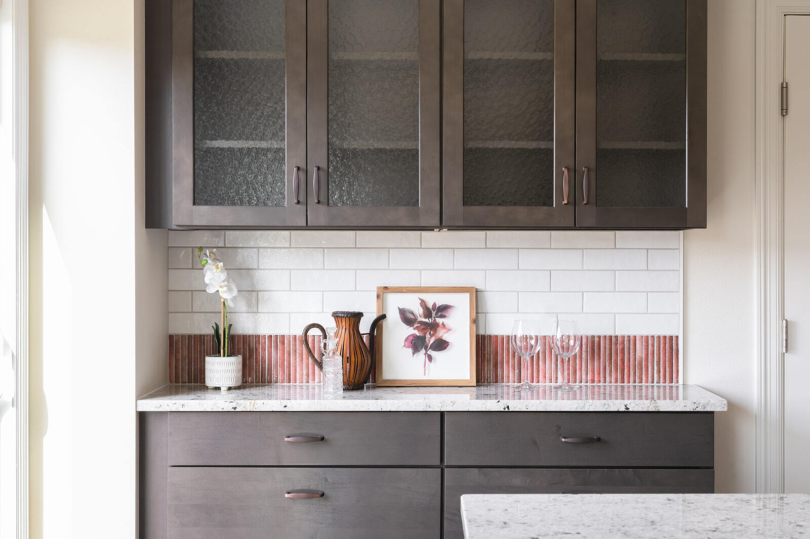 Kitchen renovation with coffee bar featuring dark cabinets with textured glass doors and white countertops