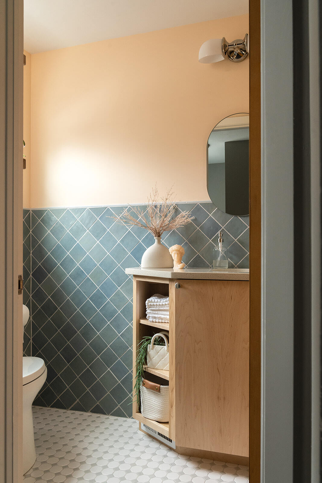 Small Bathroom Remodel in Des Moines with blue backsplash, light wood vanity, and white flooring